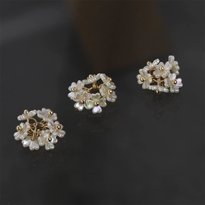 Close-up of mother of pearl flower cluster pendants with gold bead accents