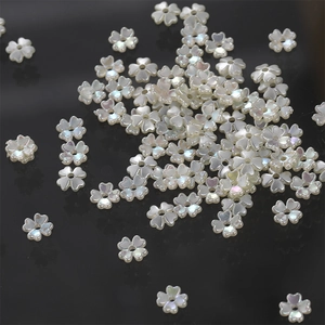 Macro detail of iridescent white four-leaf clover flower beads with central hole for DIY