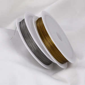 Golden and gunmetal gray craft beading wires on white spools for DIY jewelry making