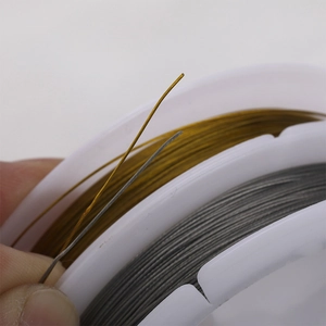 Flexible gold and silver steel beading wire for DIY jewelry making on white spools
