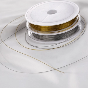 Detailed view of gold and silver beaded wires on white spools for DIY jewelry making