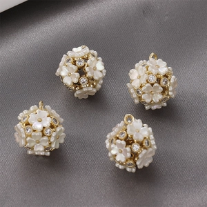 Macro detail of 14k gold plated shell flower pendants with white cubic zirconia stones