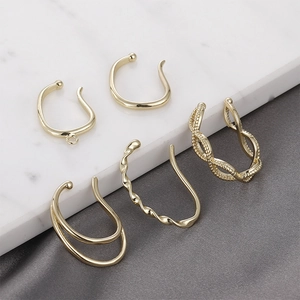 Five styles of gold-plated non-pierced ear bone clips on marble and silk display