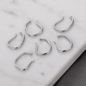 Set of six silver twisted cuff earrings for non-pierced ears on marble background