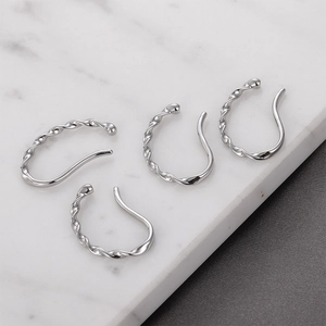 Detailed view of silver twisted ear cuffs on premium marble background for non-pierced ears