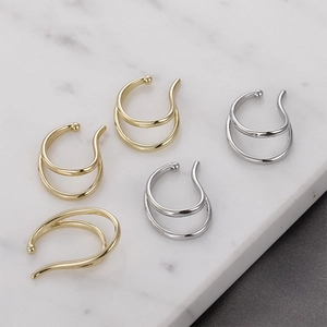 Minimalist double-layer gold and silver ear cuffs on a marble surface, non-pierced design
