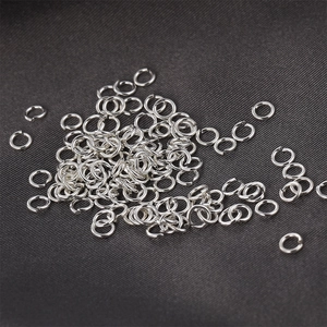 Bulk S925 sterling silver open jump rings for DIY jewelry making on dark textured background