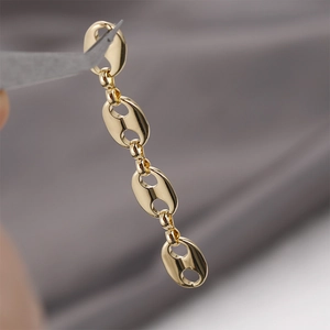 Macro detail of 14k gold-filled pig nose link chain for DIY jewelry making with polished finish