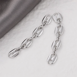 Polished silver pig nose chain earrings with minimalist vertical links on white texture