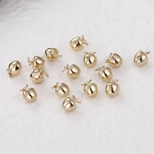 Polished 14k gold-filled 3D apple charms for DIY jewelry making on white background