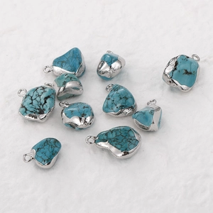 Detail of ten irregular turquoise charms with silver plated edges for DIY jewelry making