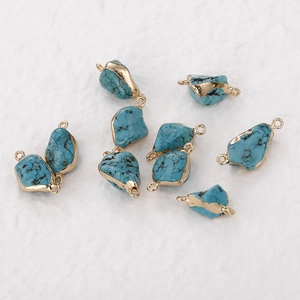Macro view of gold-plated turquoise stone charms with double connectors for jewelry making