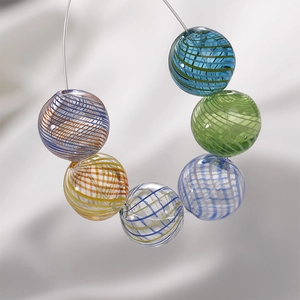 Close-up of handmade glass beads with colorful spiral patterns for DIY jewelry