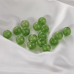 Macro view of green glass beads with white spiral textures for DIY jewelry making