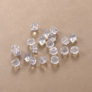 Clear silicone earring backs set on champagne gold brushed background for secure fit