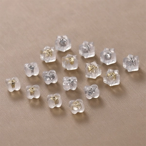 Transparent 18k gold silicone earring backs in star and flower shapes with metal cores
