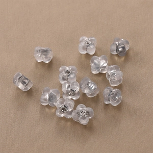 Translucent flower silicone earring backs set on soft textured fabric background