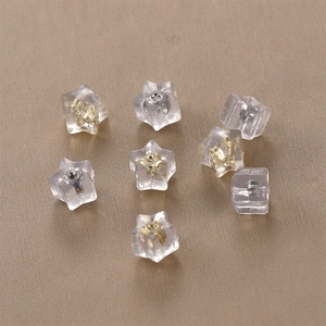 Macro detail of star-shaped silicone earring backs with gold and silver metal inserts