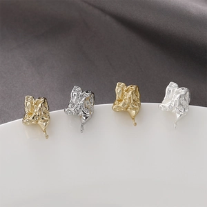 Set di orecchini a perno stile lava irregolare color oro e argento su piatto bianco