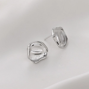 Macro shot of silver plated irregular pleated earrings with brushed metal texture