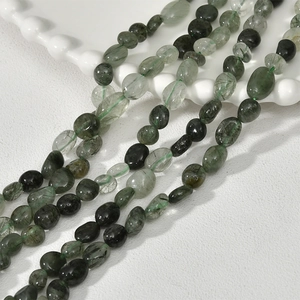 Close-up of green rutilated quartz irregular beads with natural mineral inclusions