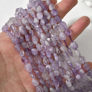 Close-up of irregular polished purple amethyst stone beads for jewelry making
