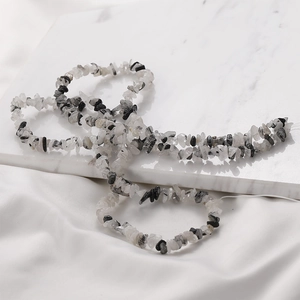 Macro shot of 3-5mm black and white irregular natural crystal stone beads on silk thread