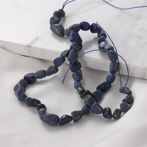 Deep blue irregular Lapis Lazuli stone beads for DIY jewelry making on white marble