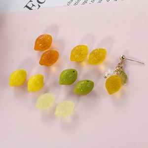 Macro detail of realistic lemon resin beads and handmade floral earrings for DIY jewelry