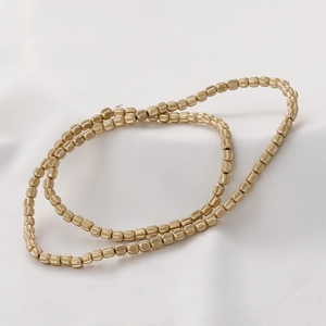Macro view of gold faceted hematite pumpkin beads with matte metallic texture