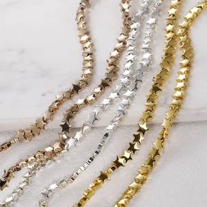 Close-up of star-shaped DIY beads in gold, silver, and rose gold finishes on marble