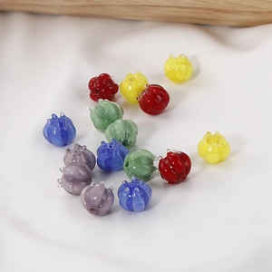 Close-up of colorful bell orchid glass beads for DIY jewelry making on white silk