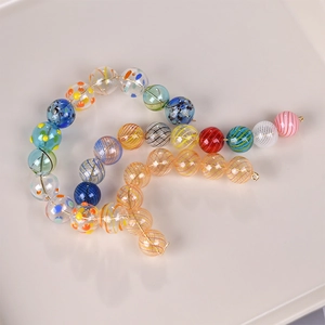 Close-up of colorful striped glass beads and hollow bubble beads for jewelry DIY crafts