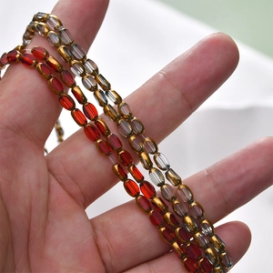Macro shot of oval red and grey crystal glass beads with golden coated edges for DIY jewelry