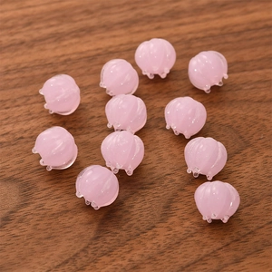 Detailed view of pink translucent lily of the valley glass beads on wooden texture