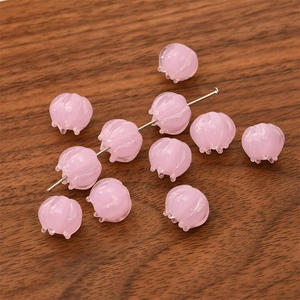 Pink glass bell orchid beads for DIY jewelry making on dark wood background