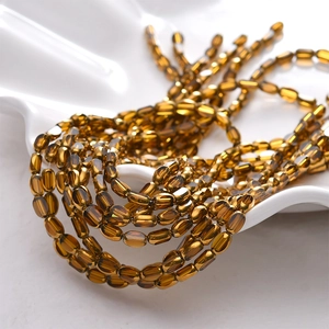 Faceted amber gold oval glass beads on a strand for DIY jewelry making and necklace crafts