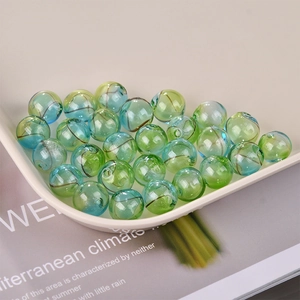 Close-up of hollow glass beads with blue and green gradient and spiral swirl texture