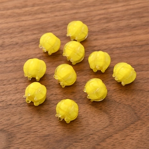 Macro shot of yellow bell orchid lily of the valley glass beads on a wood table