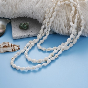 Detail view of multi-layer white spiral seashell beaded necklace for beach vacations