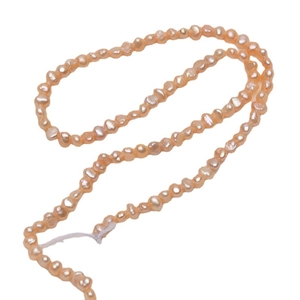 Filo di perle d'acqua dolce barocche rosa da 3-4mm con texture organiche su sfondo bianco