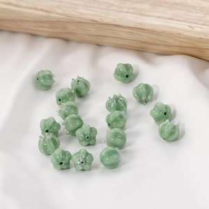 Macro shot of light green glass flower beads with white marbling for DIY jewelry making