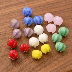 Colorful lily of the valley glass beads in various shades on a rustic wooden background