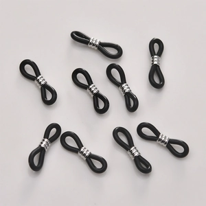 Macro shot of 8-piece black silicone eyeglass chain connectors with silver metal loops