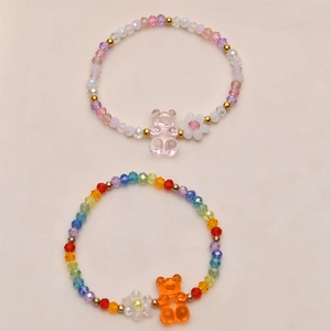 Nahaufnahme von bunten Bärenanhängern und facettierten Perlen auf DIY-Armbändern