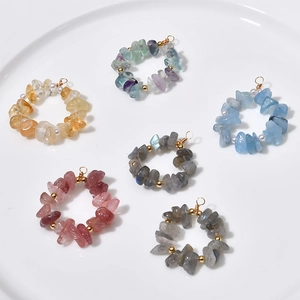 Macro shot of assorted natural crystal stone hoop pendants with gold wire and pearl detail
