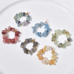 Detailed close-up of handmade natural stone ring pendants with gold beads and pearls