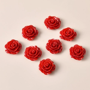 Flat lay of vintage style red resin rose flower charms for DIY jewelry and hair accessories