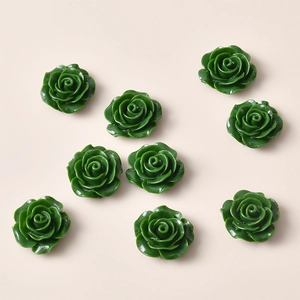 Detailed macro view of dark green resin rose flower flatback cabochons for DIY crafts