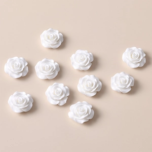 Detail of ten white resin rose flower charms for DIY jewelry making and hair accessories